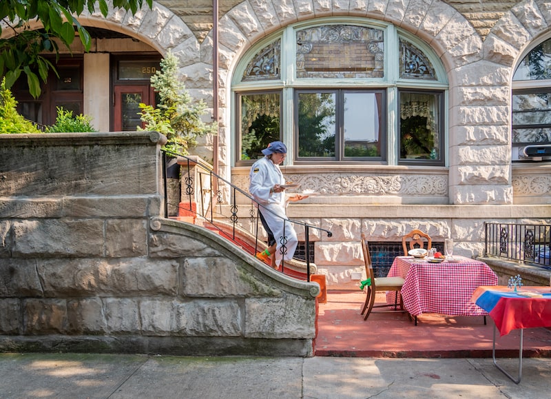 A chef walking downstairs to bring food to a table